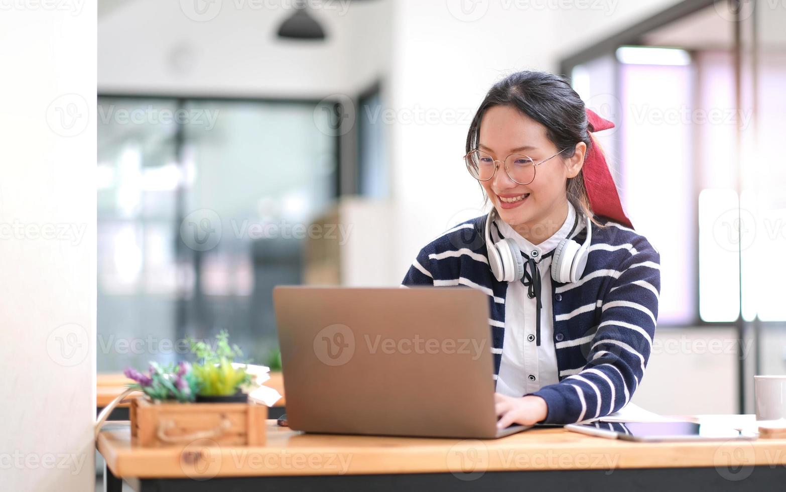 étudiant apprenant sur ordinateur portable à l'intérieur - cours ou formation pédagogique, séminaire, concept d'éducation en ligne, femme asiatique avec ordinateur portable moderne et écouteurs apprenant à la maison photo