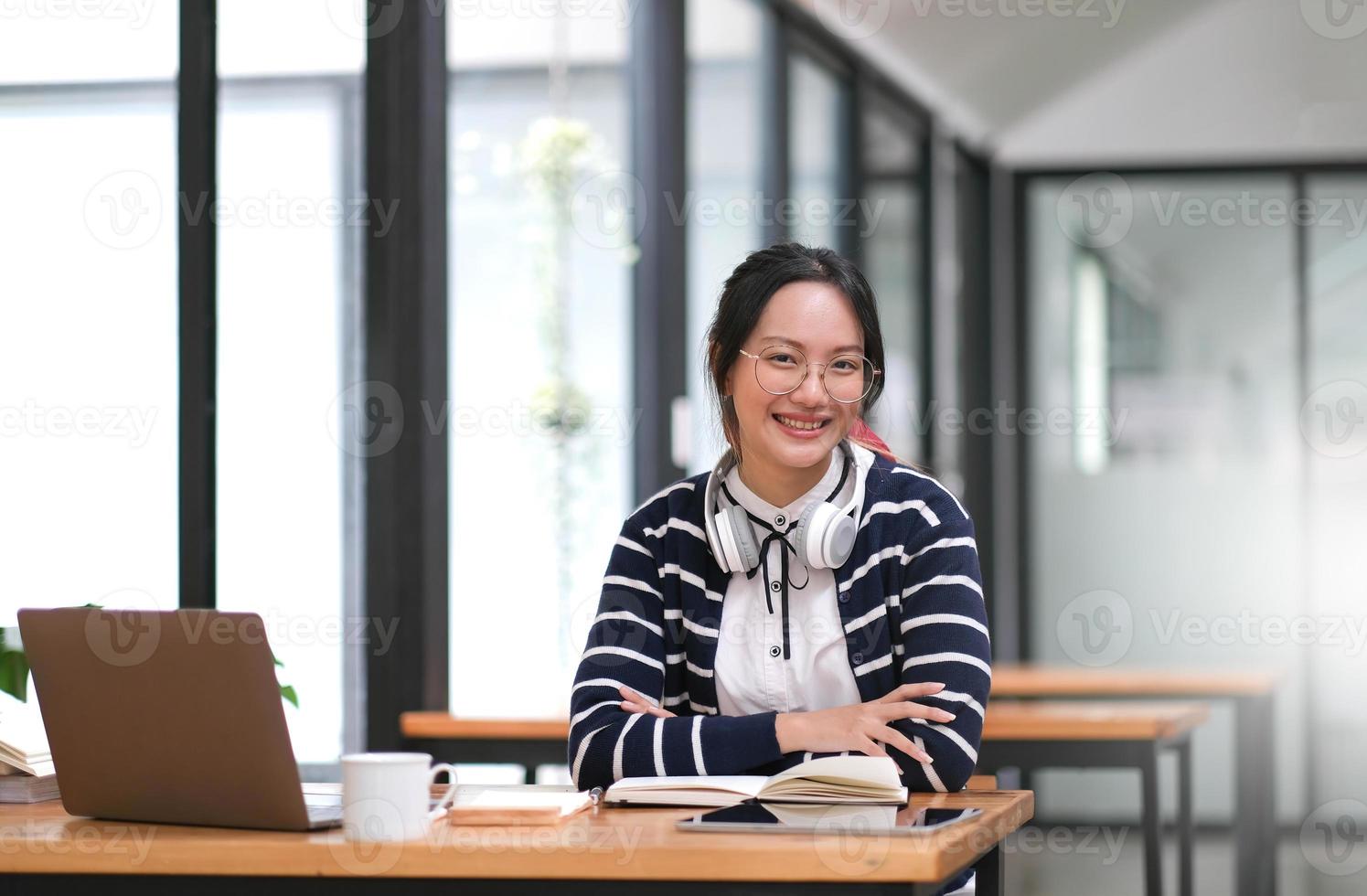 femme asiatique travaillant avec un ordinateur portable au bureau à domicile, femme asiatique. fille heureuse apprenant par internet, étudie l'éducation en ligne, le commerce électronique. photo