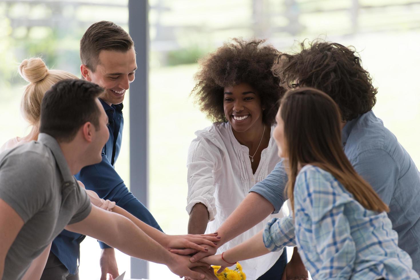 groupe de démarrage multiethnique de jeunes gens d'affaires célébrant le succès photo