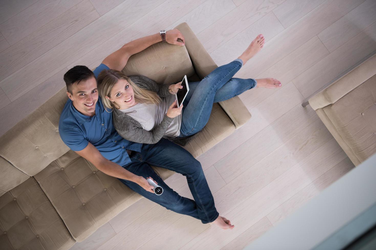 jeune couple dans le salon avec vue sur le dessus de la tablette photo