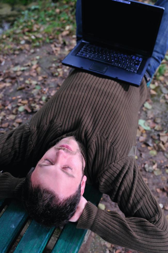 jeune homme d'affaires travaillant sur un ordinateur portable en plein air photo