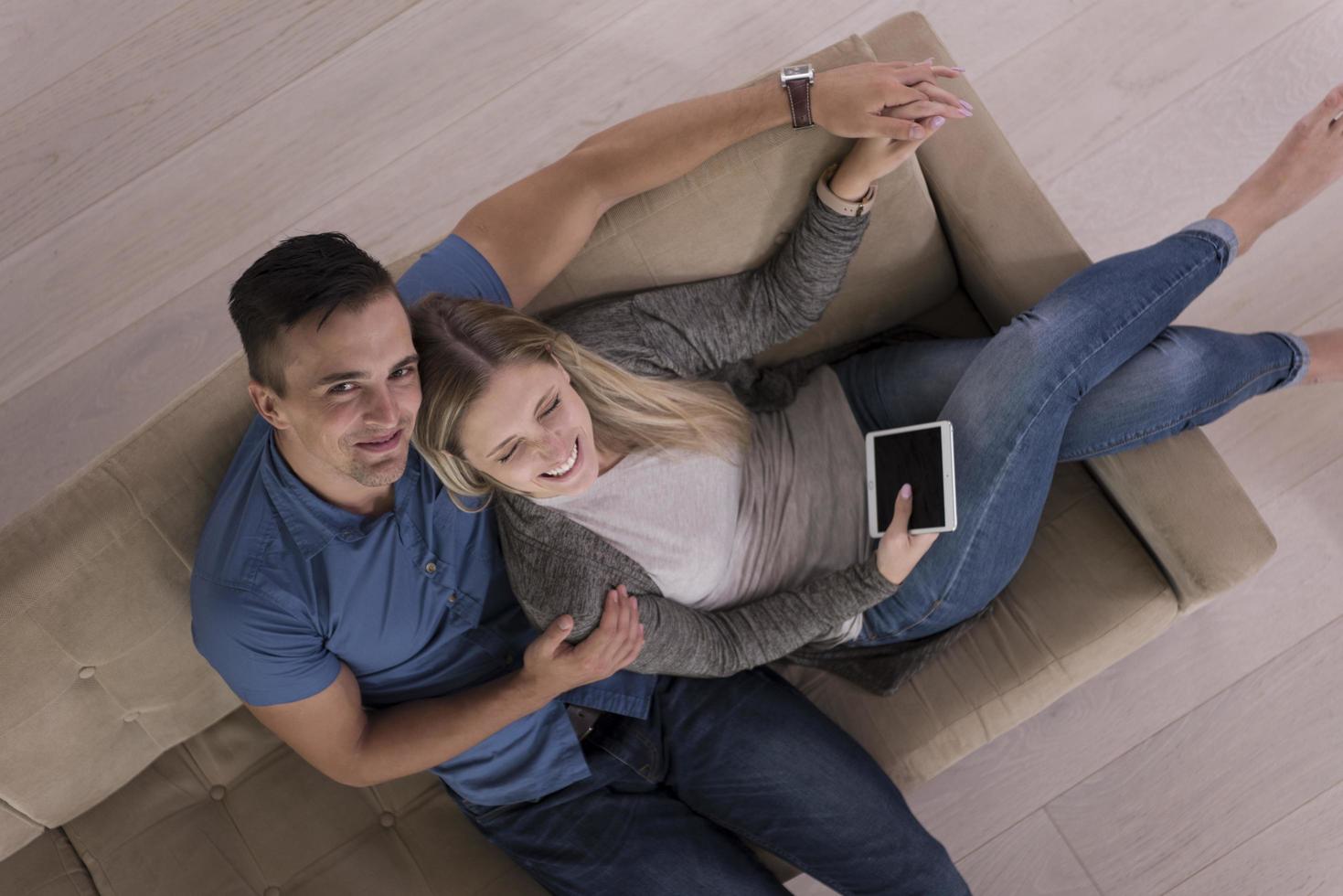 jeune couple dans le salon avec vue sur le dessus de la tablette photo