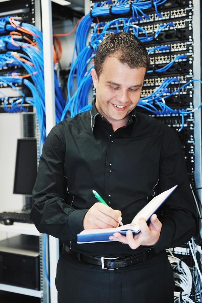 jeune ingénieur informatique dans la salle des serveurs du centre de données photo