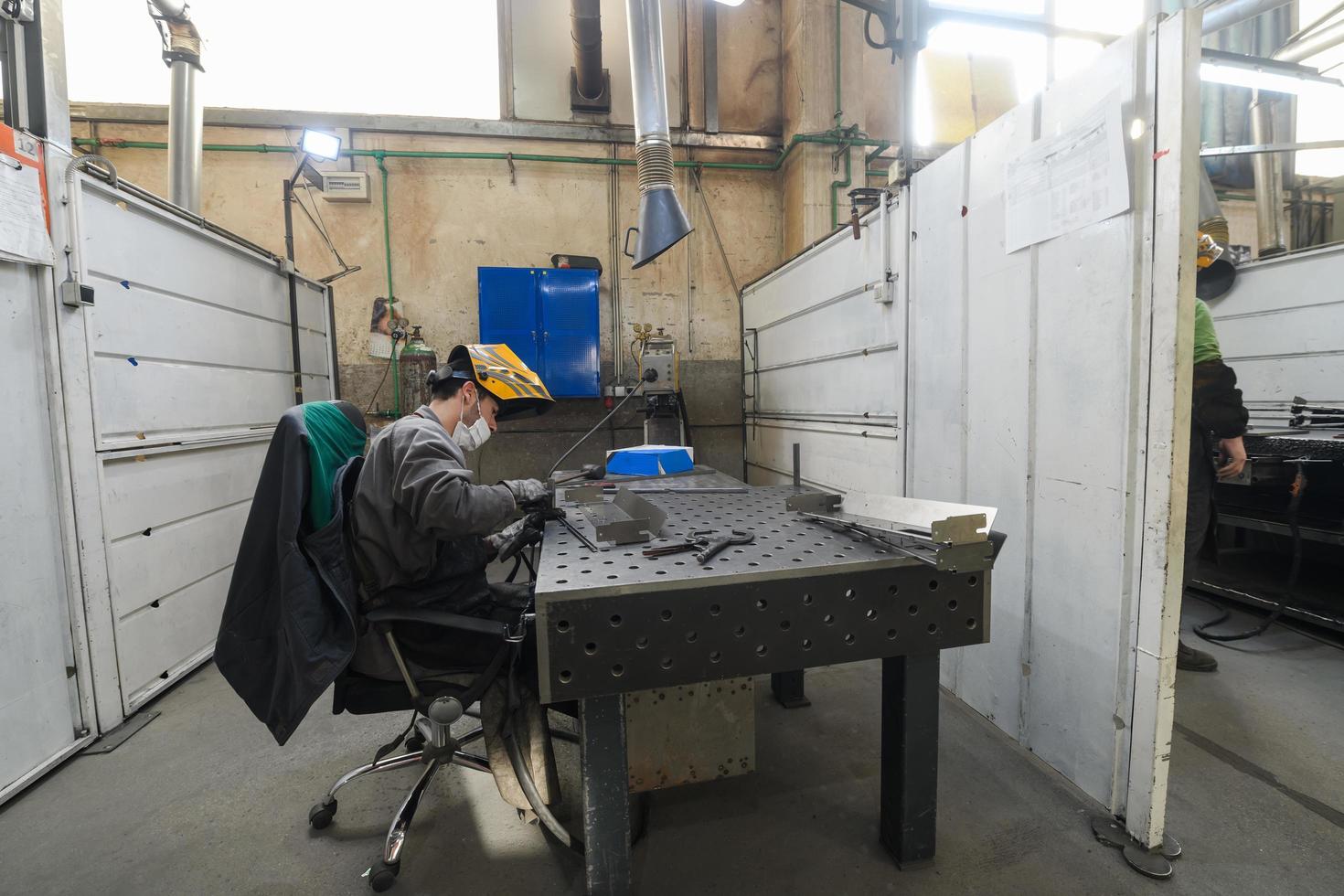 ouvrier de l'industrie métallurgique travaillant en usine, portant un masque protecteur pendant la pandémie de coronavirus ou de covid19. photo