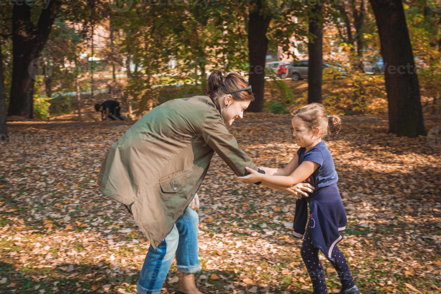 heureuse mère et fille jouant dans le parc d'automne. photo