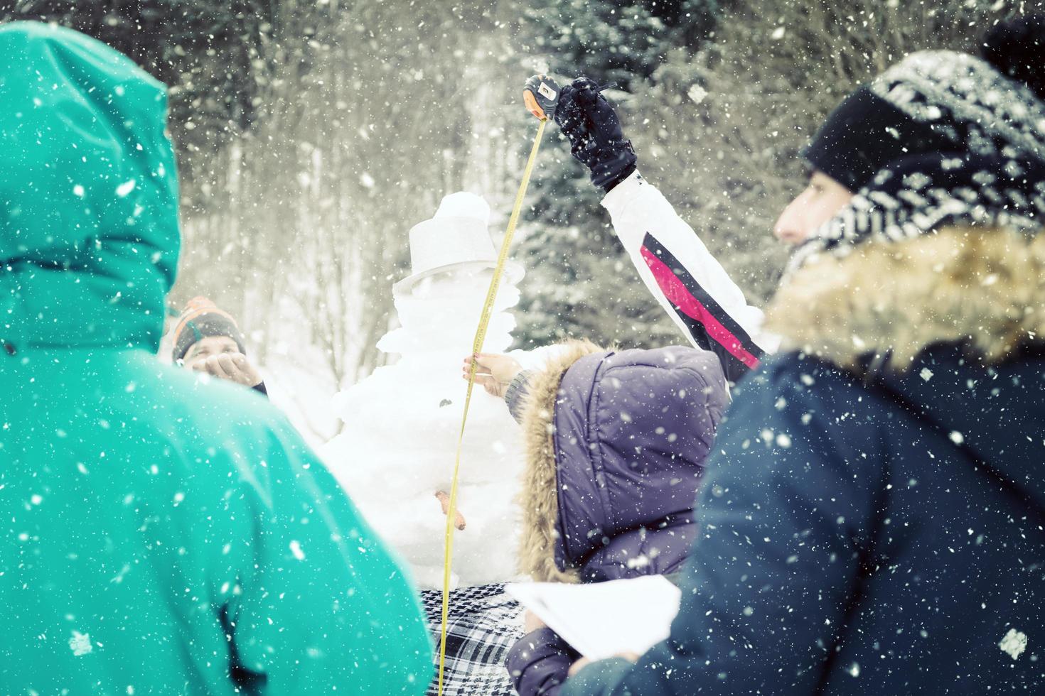 les jeunes mesurent la hauteur du bonhomme de neige fini photo