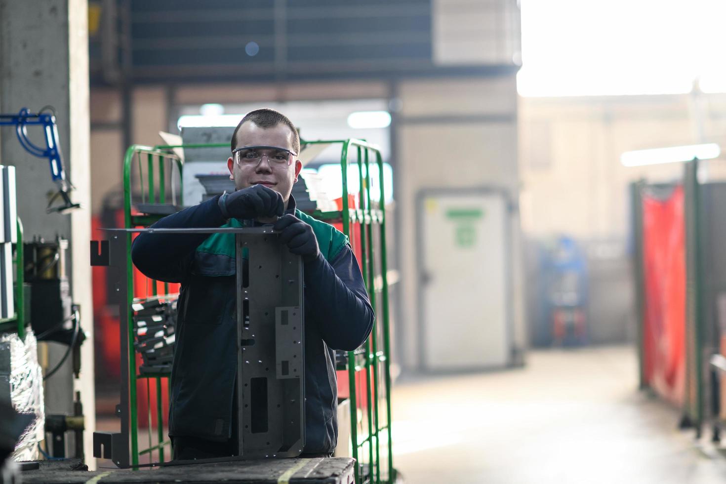 un ouvrier en uniforme travaillant dans une usine moderne de production et de transformation de métaux assemble des pièces d'une nouvelle machine sur son bureau photo