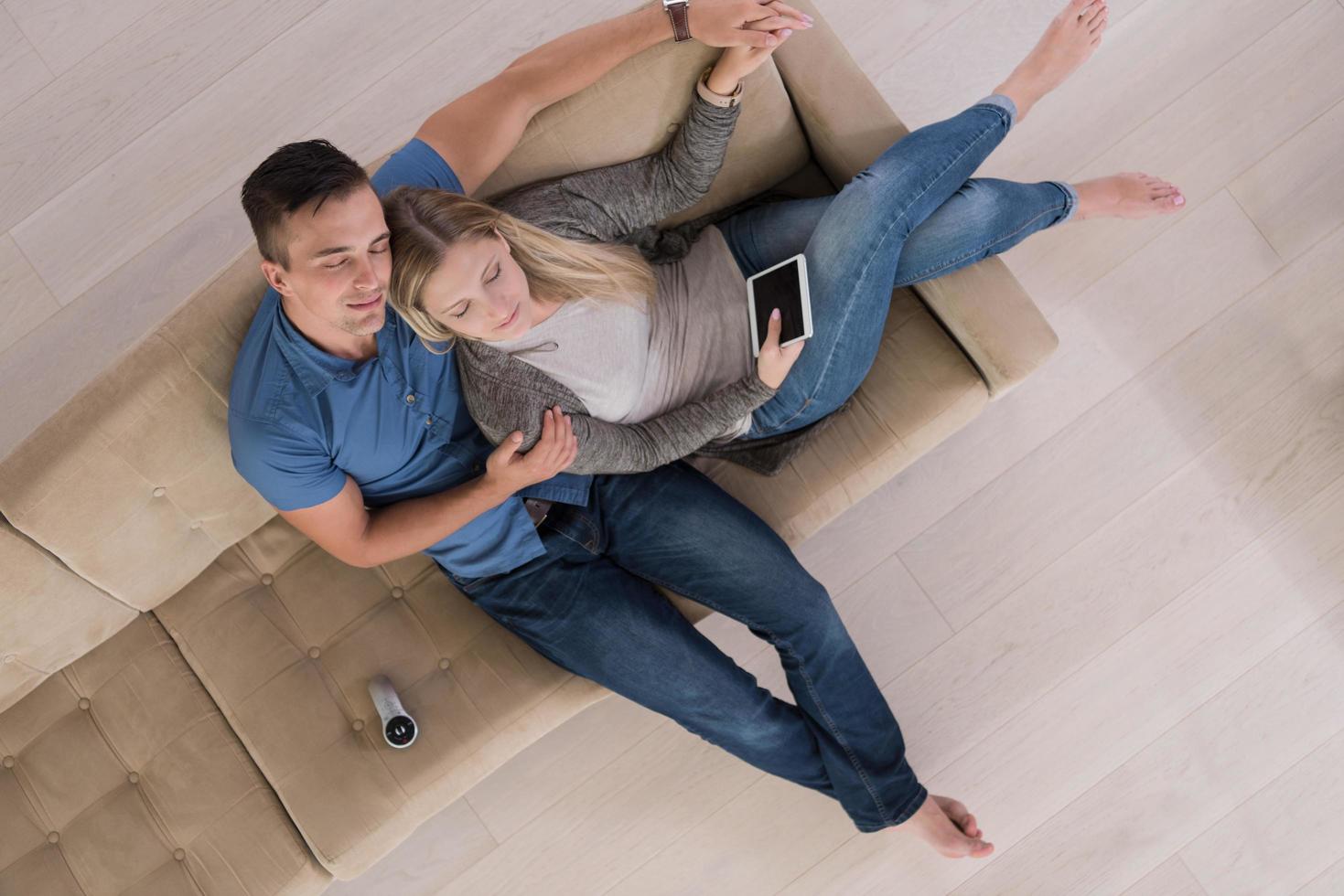 jeune couple dans le salon avec vue sur le dessus de la tablette photo