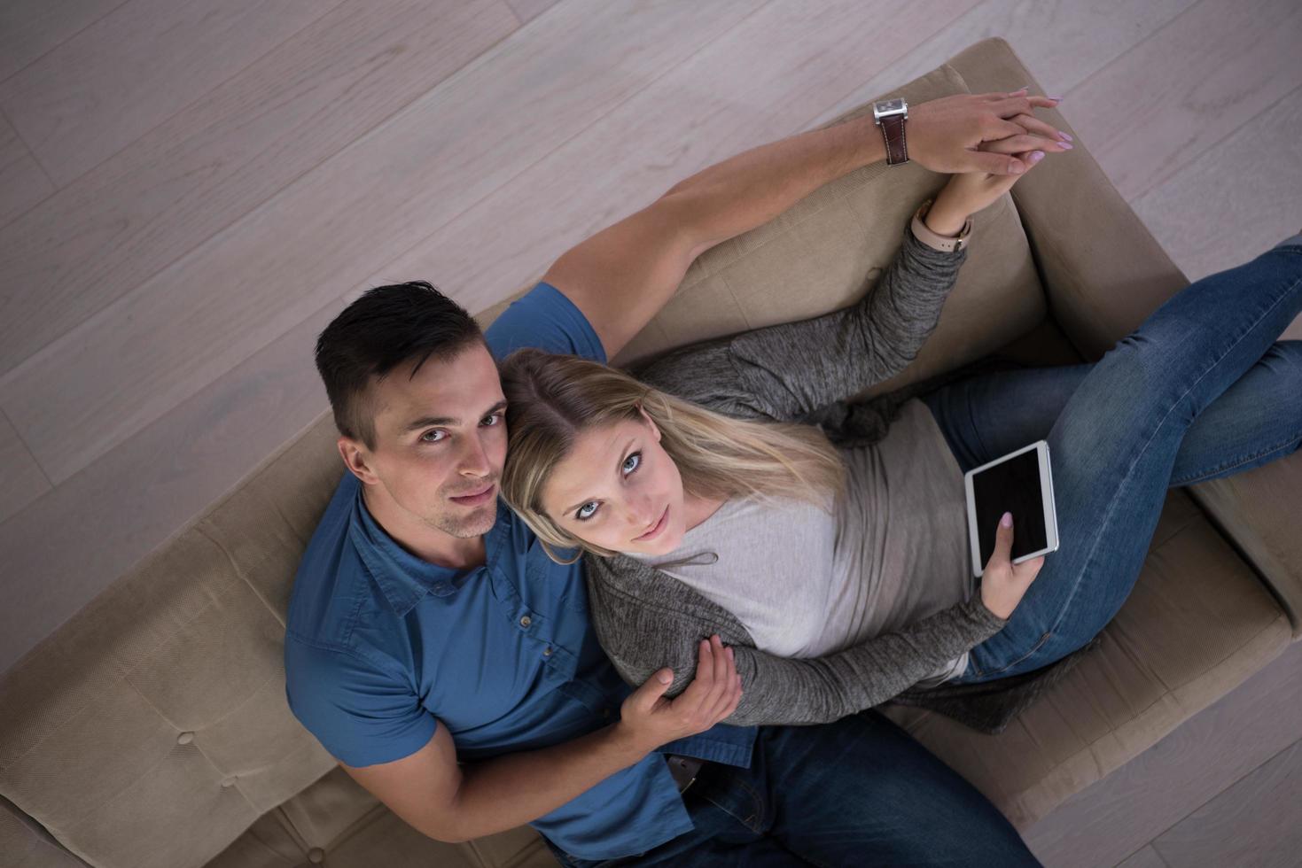 jeune couple dans le salon avec vue sur le dessus de la tablette photo