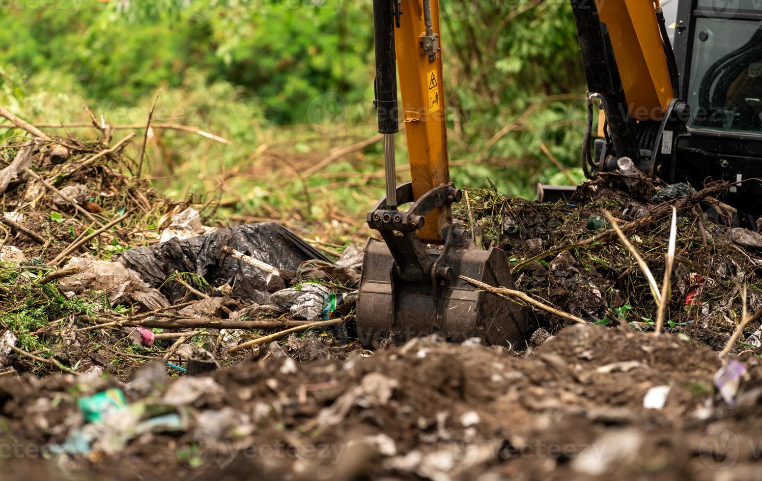 rétrocaveuse creusant le sol sur le chantier de construction. seau de pelleteuse creusant le sol. défrichage et essouchement. digger travaillant sur le chantier de construction de routes. engin de terrassement. véhicule d'excavation. développement agraire. photo