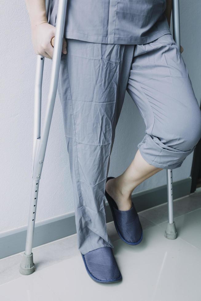 jeune physiothérapeute asiatique travaillant avec une femme âgée sur la marche avec un déambulateur photo