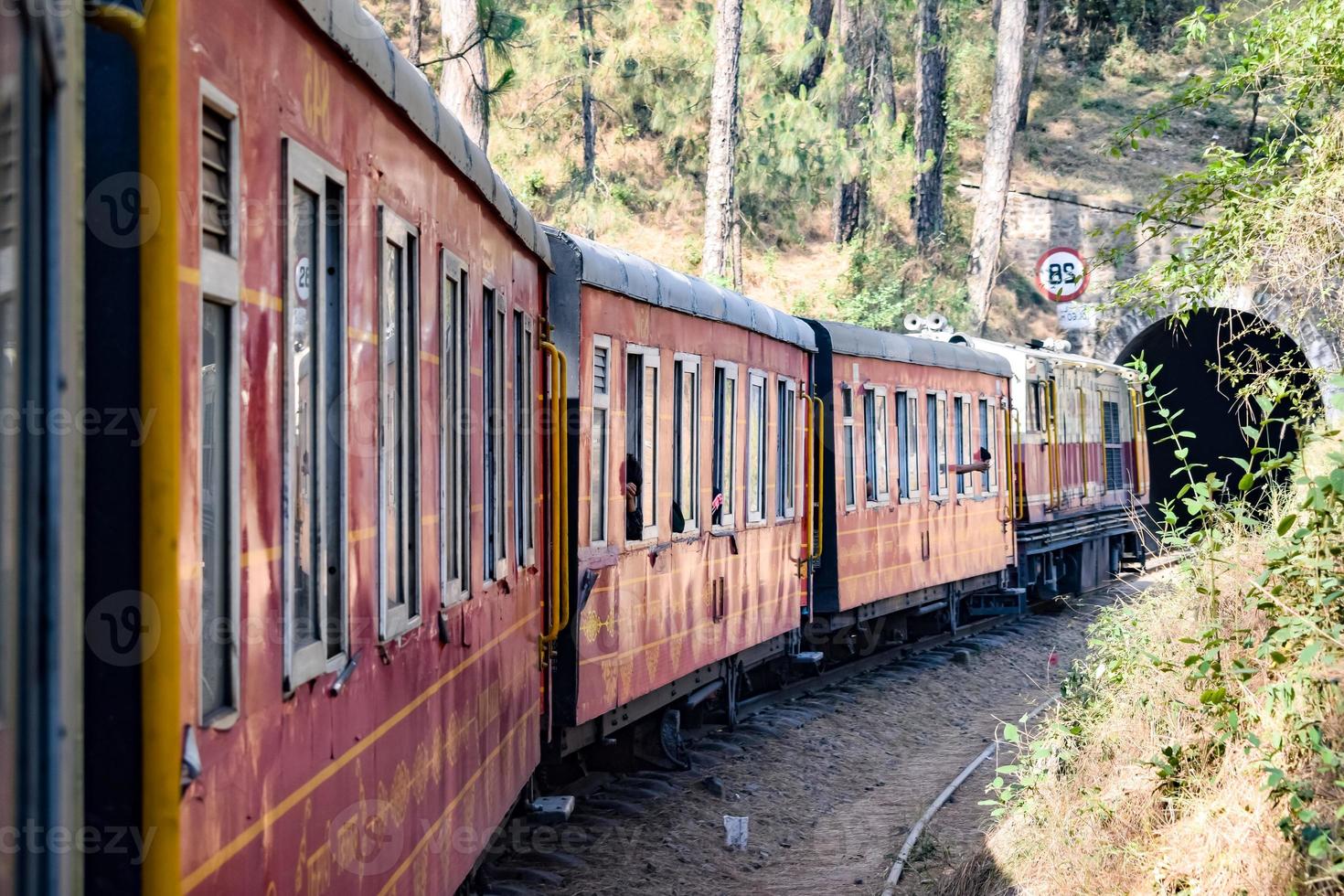 petit train se déplaçant sur les pentes de la montagne, belle vue, un côté montagne, un côté vallée se déplaçant sur le chemin de fer jusqu'à la colline, parmi la forêt naturelle verdoyante. train jouet de kalka à shimla en inde, train indien photo