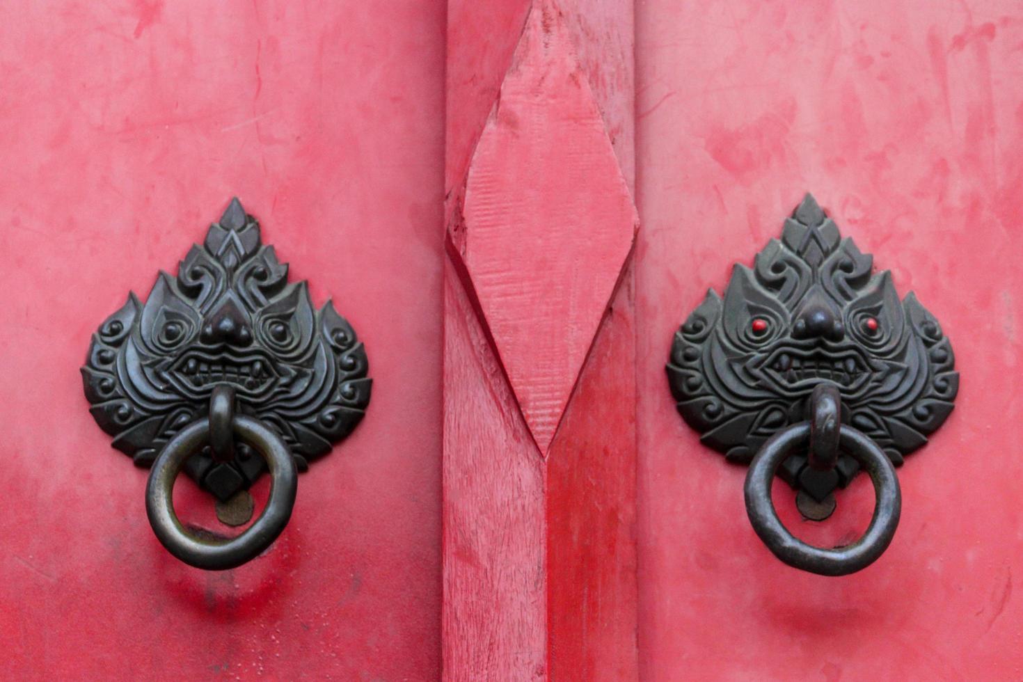 heurtoir de porte vintage sur porte rouge en bois dans le vieux style chinois classique photo