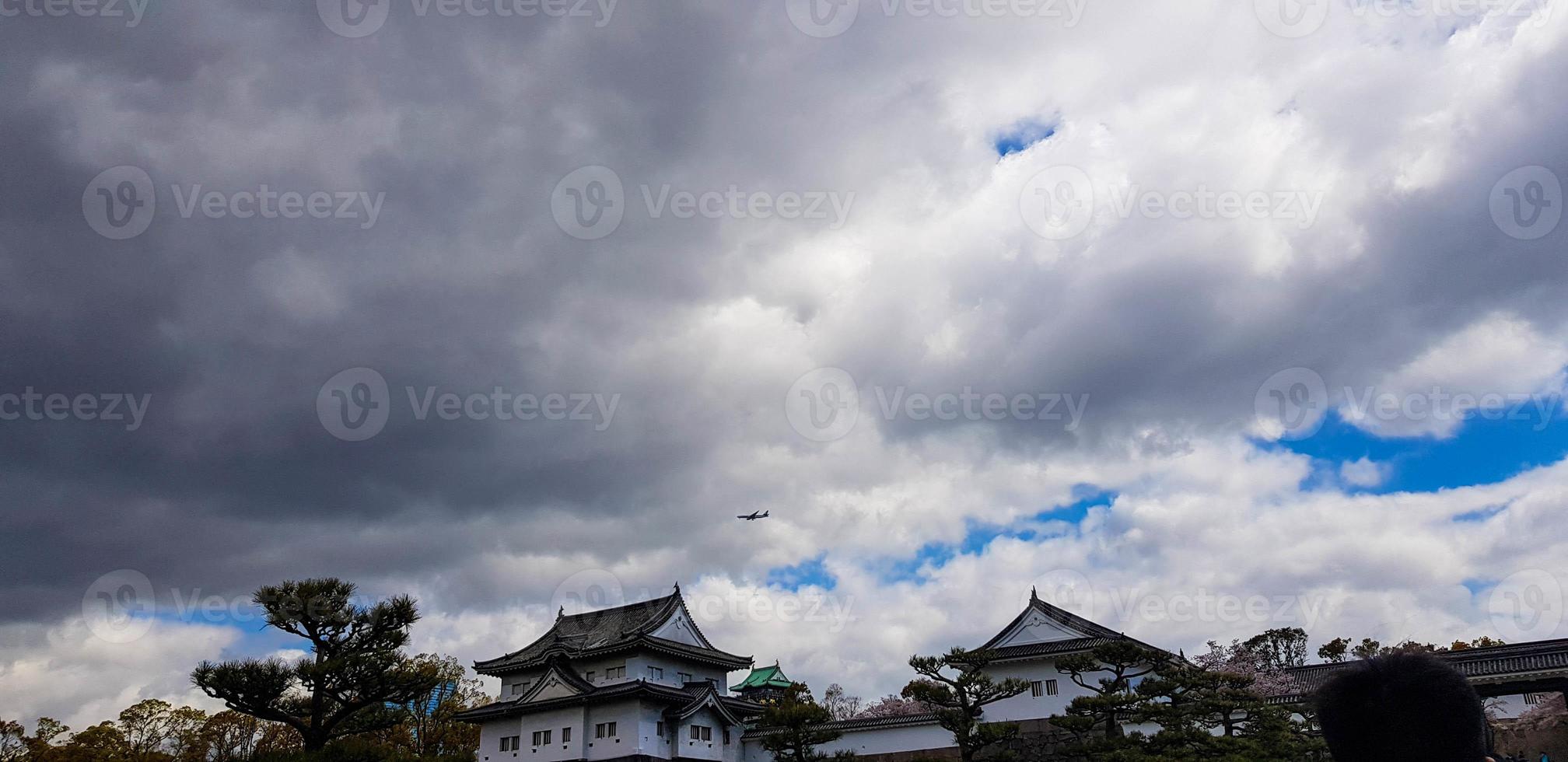 les environs du château d'osaka au printemps avec un ciel magnifique, une rivière calme et des fleurs de cerisier. photo