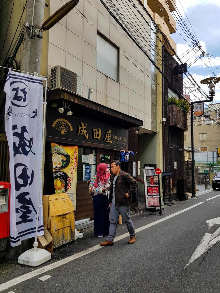 osaka, japon le 10 avril 2019. un jeune homme musulman et une femme musulmane entreront dans un magasin de ramen halal à osaka. photo