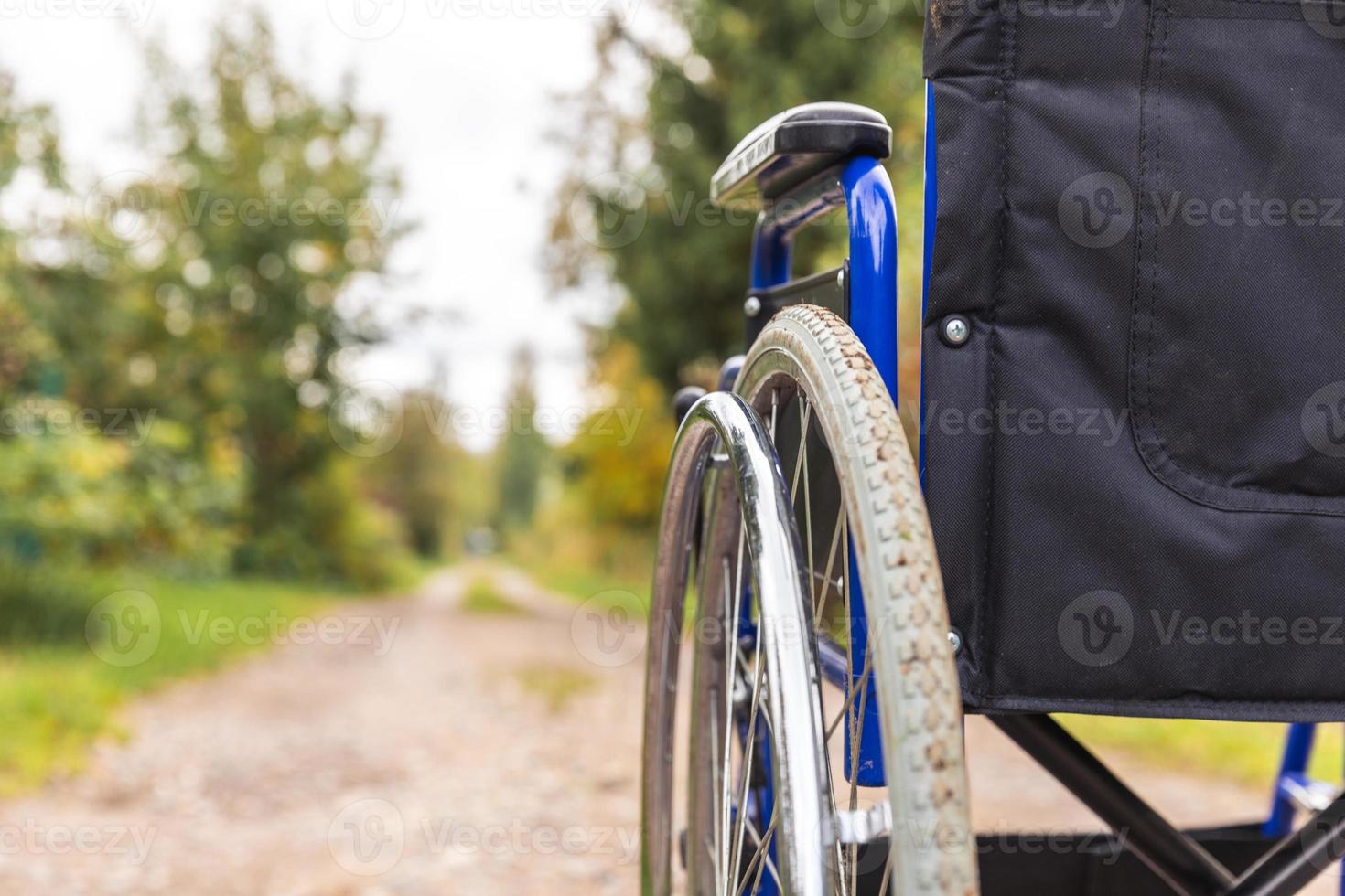 fauteuil roulant vide debout sur la route en attente de services aux patients. fauteuil roulant pour personne handicapée garé à l'extérieur. accessible pour personne handicapée. concept médical de soins de santé. photo