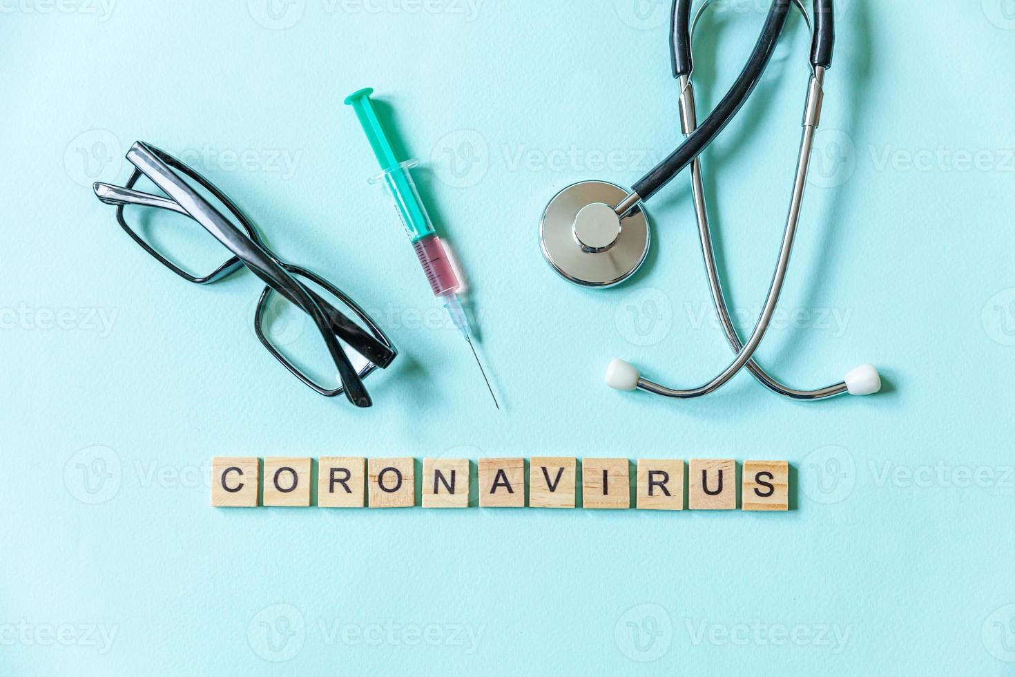 expression de texte coronavirus seringue lunettes et stéthoscope sur fond bleu pastel. nouveau coronavirus 2019-ncov mers-cov covid-19 concept de vaccin contre le virus du coronavirus du syndrome respiratoire du moyen-orient. photo