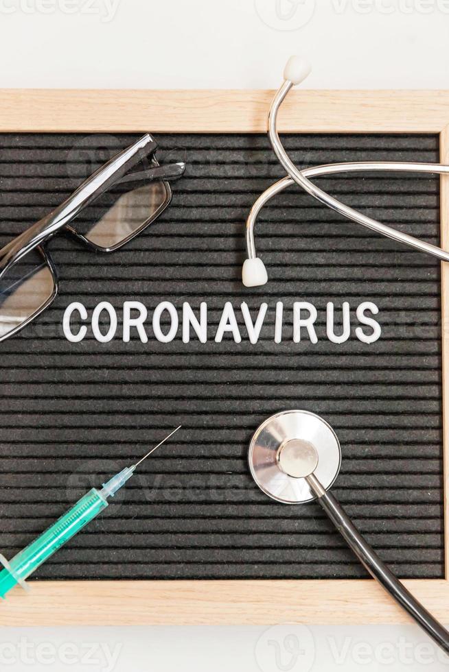 expression de texte coronavirus seringue et stéthoscope sur fond de tableau noir. nouveau coronavirus 2019-ncov, mers-cov coronavirus du syndrome respiratoire du moyen-orient originaire de wuhan en chine photo