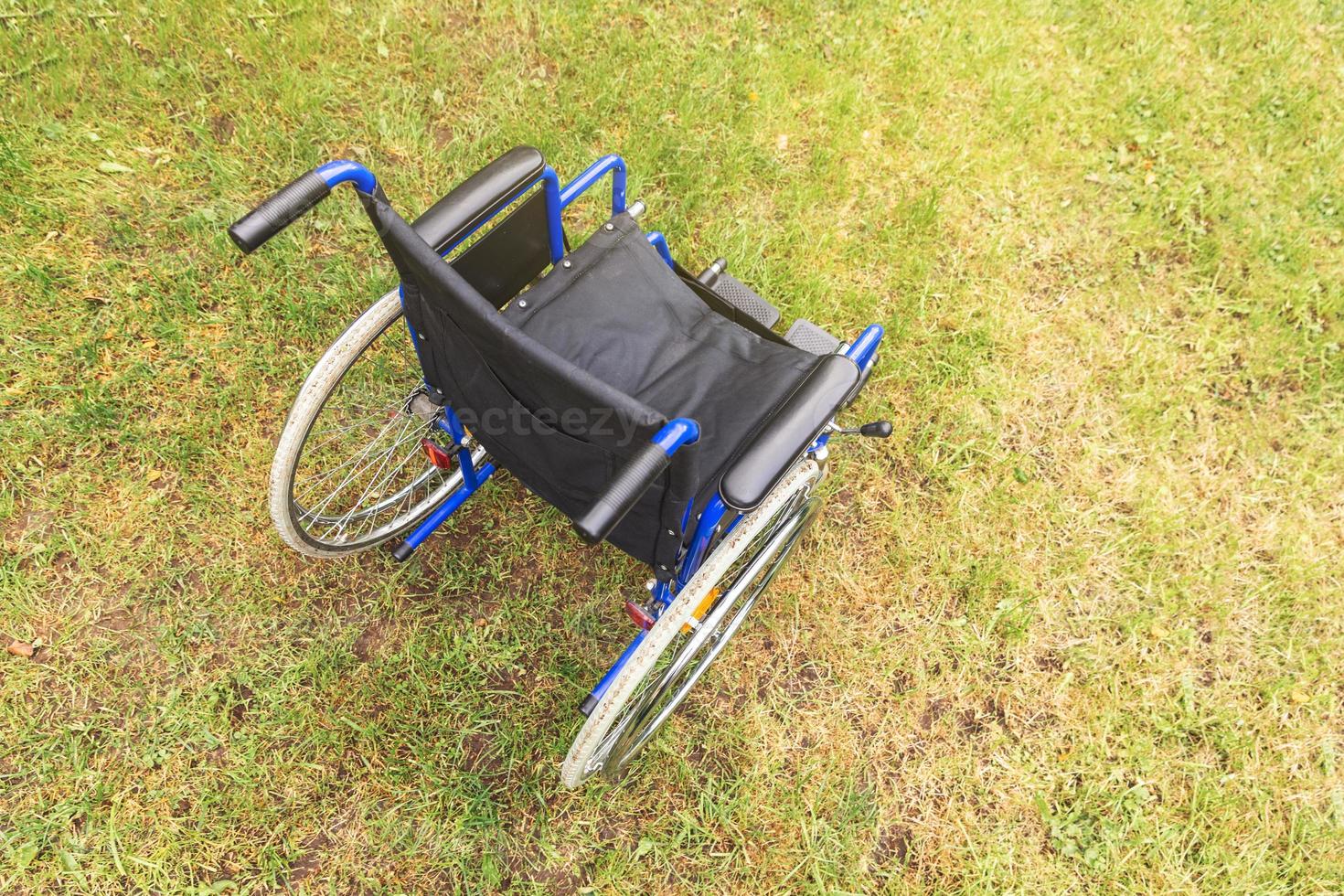 fauteuil roulant vide debout dans le parc de l'hôpital en attente de services aux patients. fauteuil roulant pour personne handicapée garé à l'extérieur. accessible pour personne handicapée. concept médical de soins de santé. photo