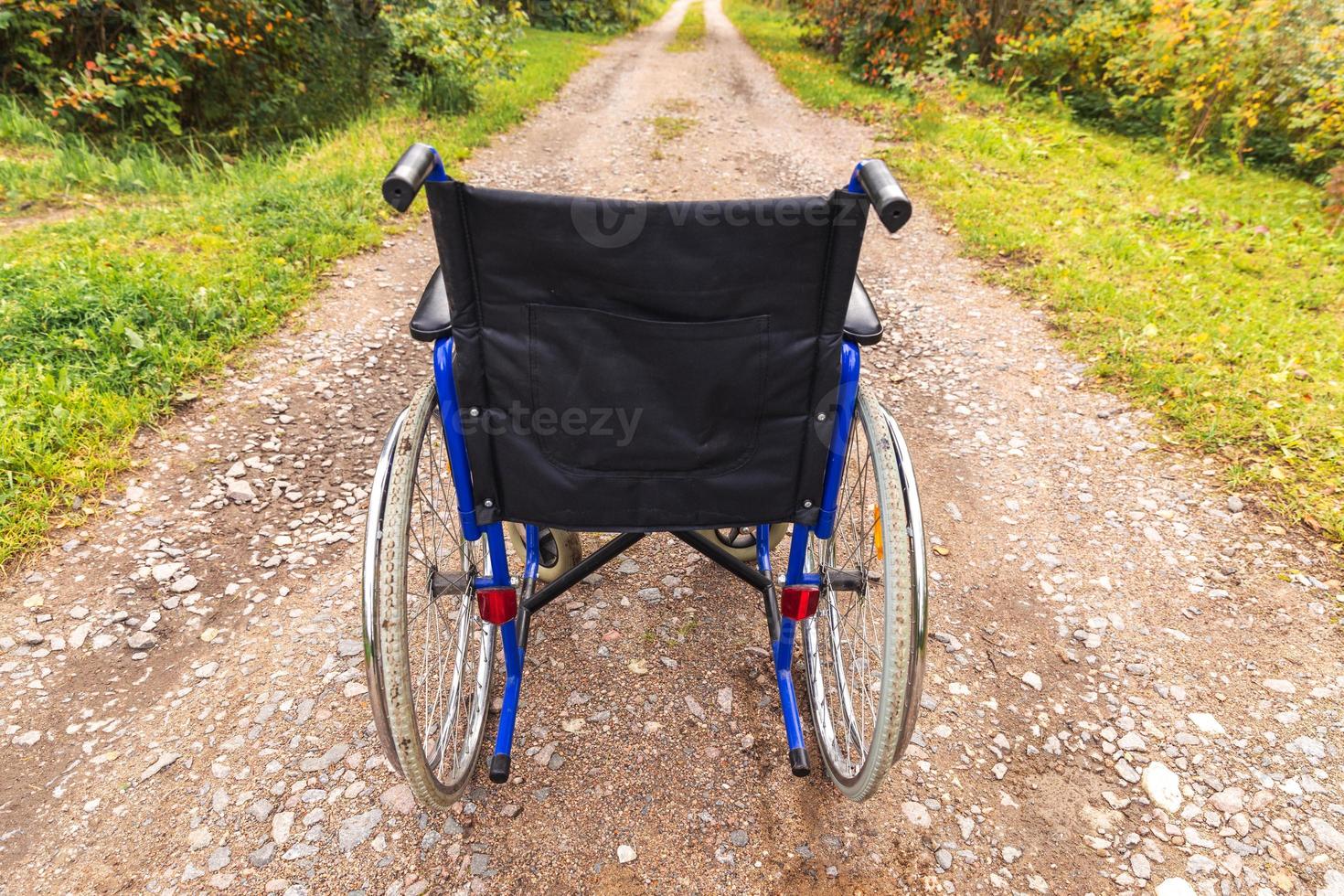 fauteuil roulant vide debout sur la route en attente de services aux patients. fauteuil roulant pour personne handicapée garé à l'extérieur. accessible pour personne handicapée. concept médical de soins de santé. photo