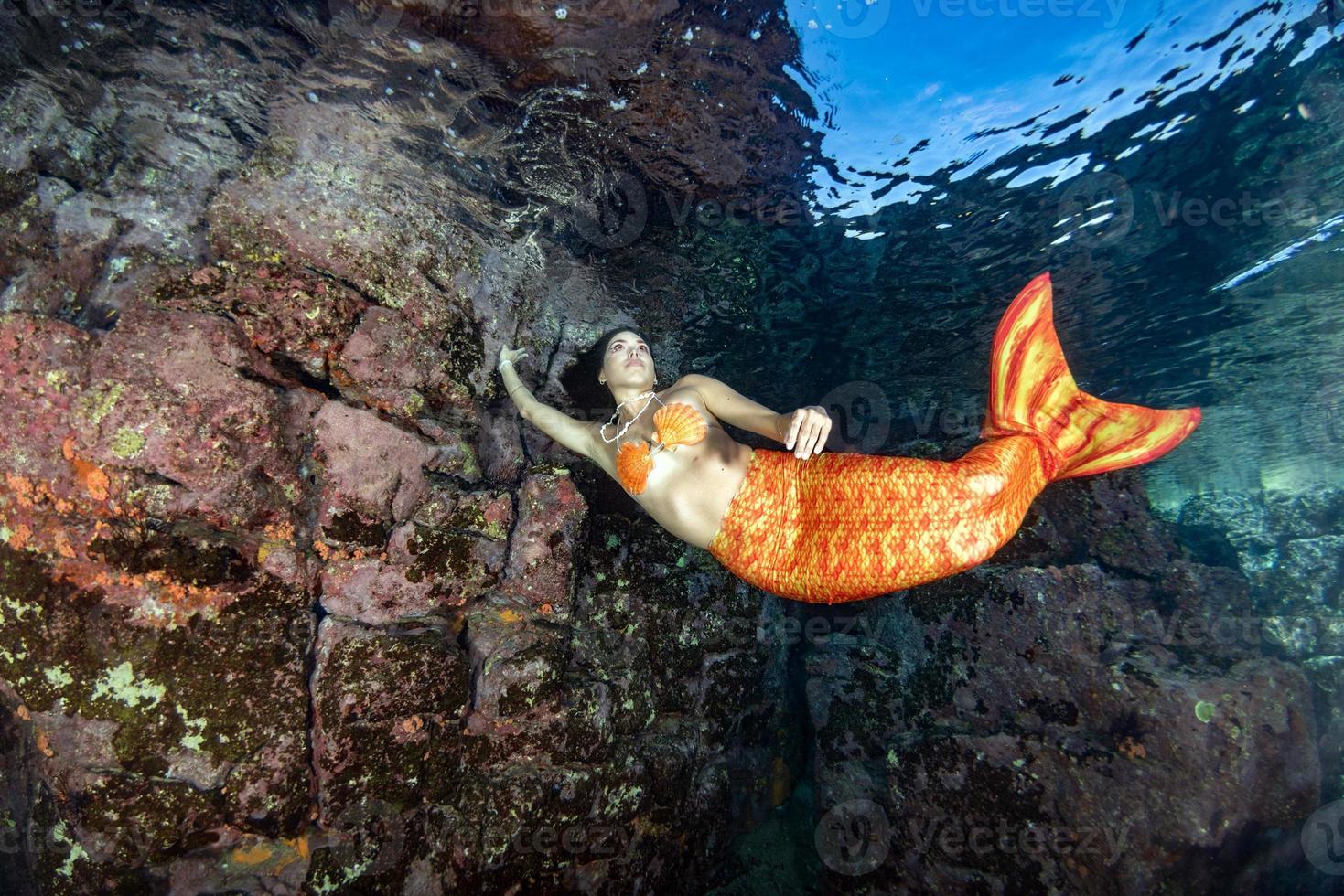 sirène nageant sous l'eau dans la mer d'un bleu profond photo