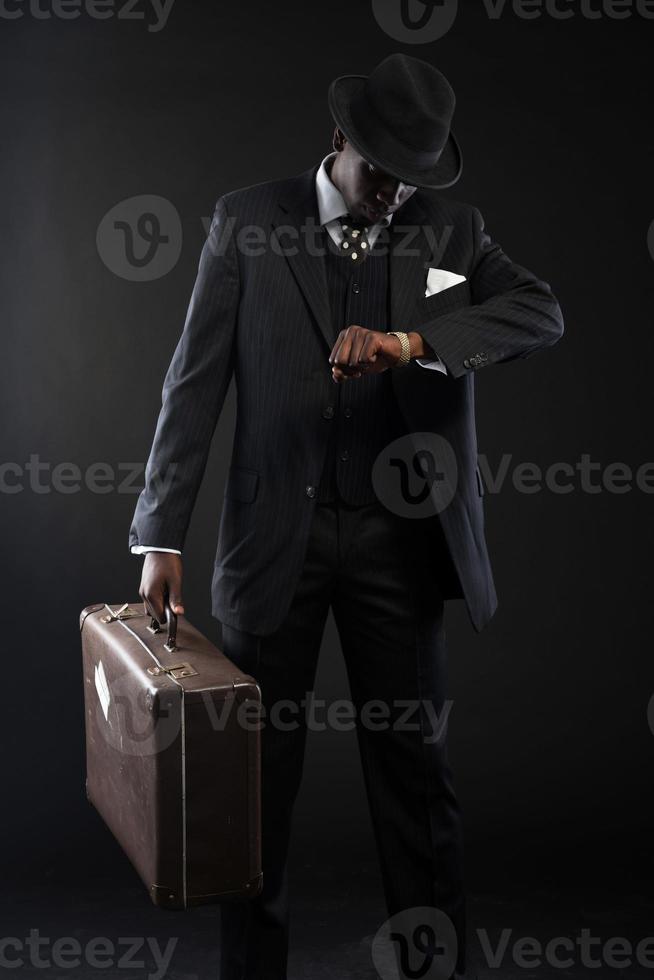 voyageur afro-américain rétro portant costume rayé et cravate. photo