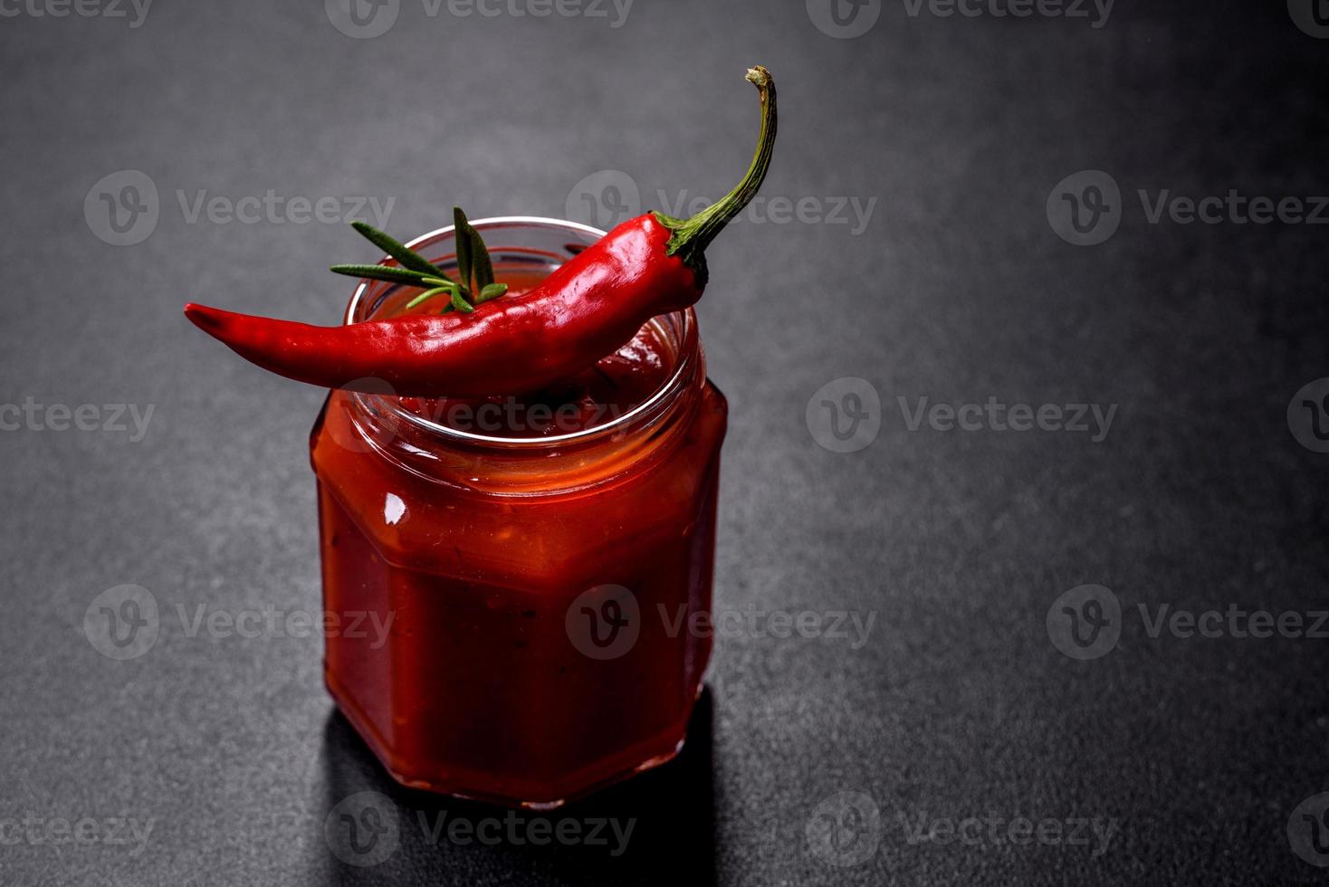 bocal en verre avec des pâtes de tomates épicées classiques faites maison ou une sauce à pizza avec des épices et des herbes photo