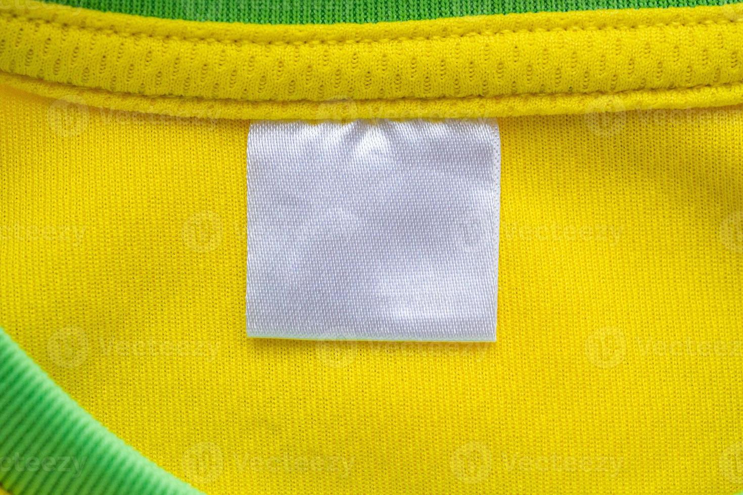 Étiquette de vêtements textiles blanc vierge sur la texture de jersey de tissu de vêtements de sport jaune photo