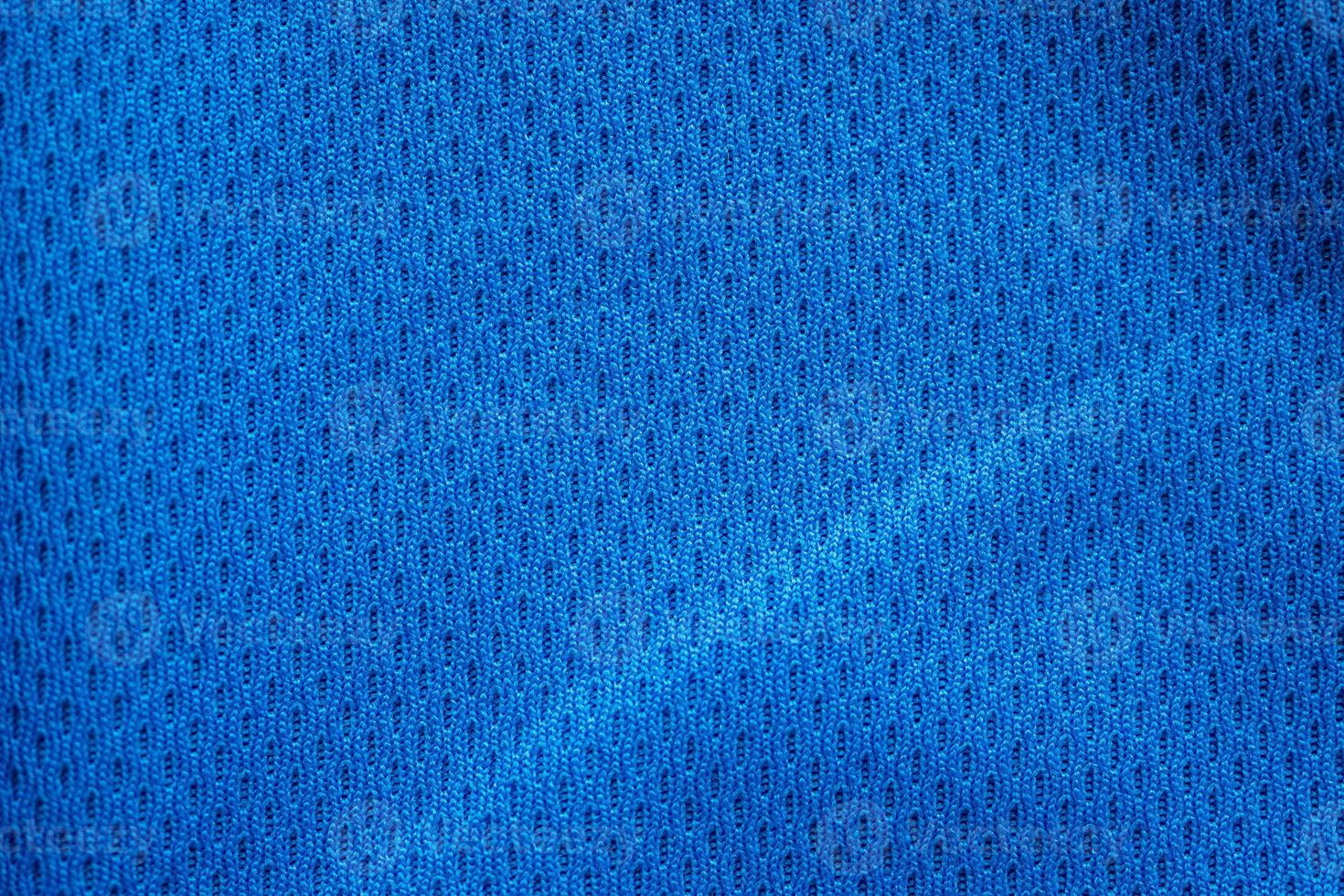 maillot de football de vêtements de sport en tissu bleu avec fond de texture en maille d'air photo