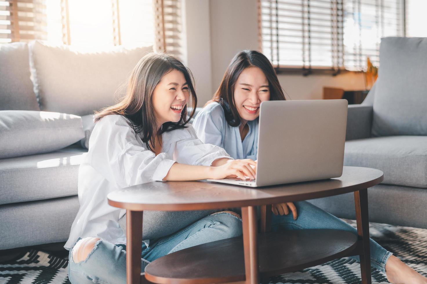 deux, femmes asiatiques, rire, quoique, travailler, à, ordinateur portable, chez soi photo