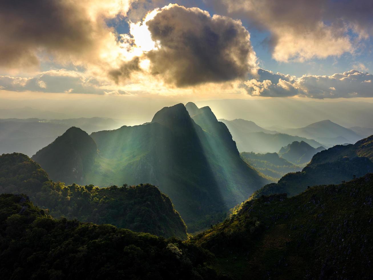 soleil qui brille à travers les nuages et les montagnes photo