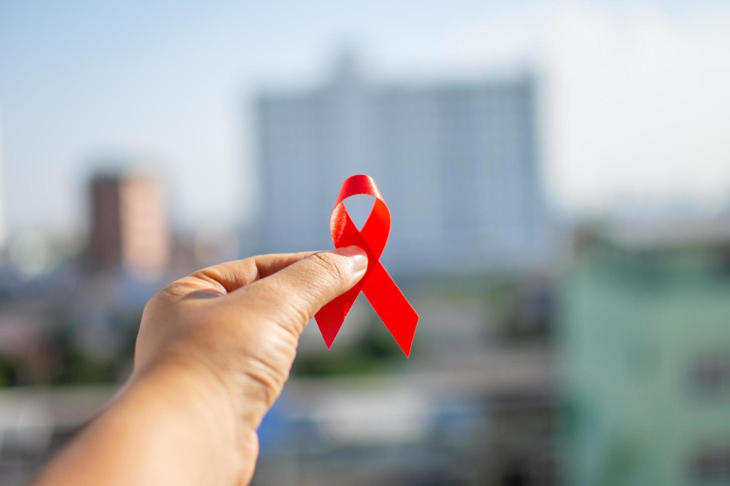 ruban rouge à la main pour la journée mondiale du sida photo