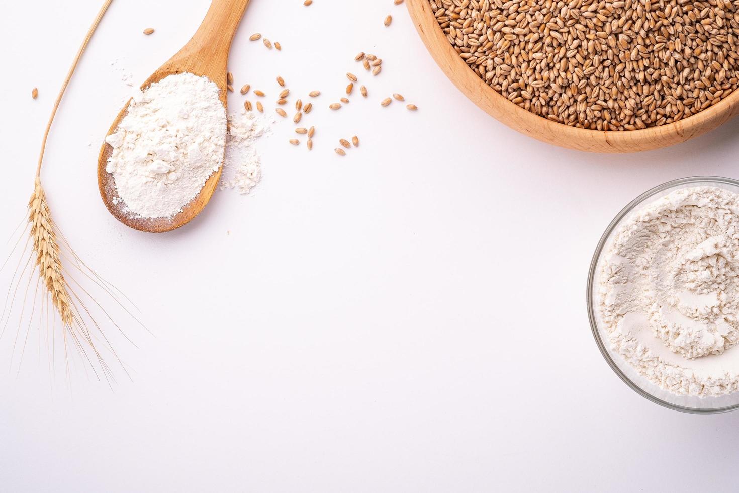 graines et grains de blé dans un bol en bois sur fond blanc photo