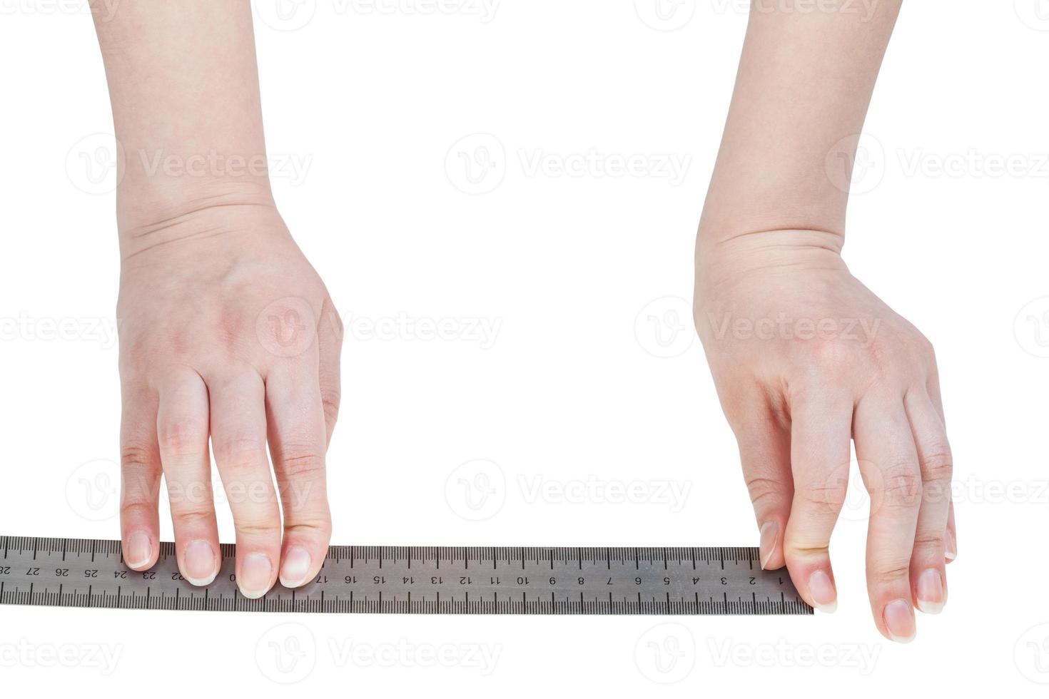 mains féminines avec règle métallique isolée photo