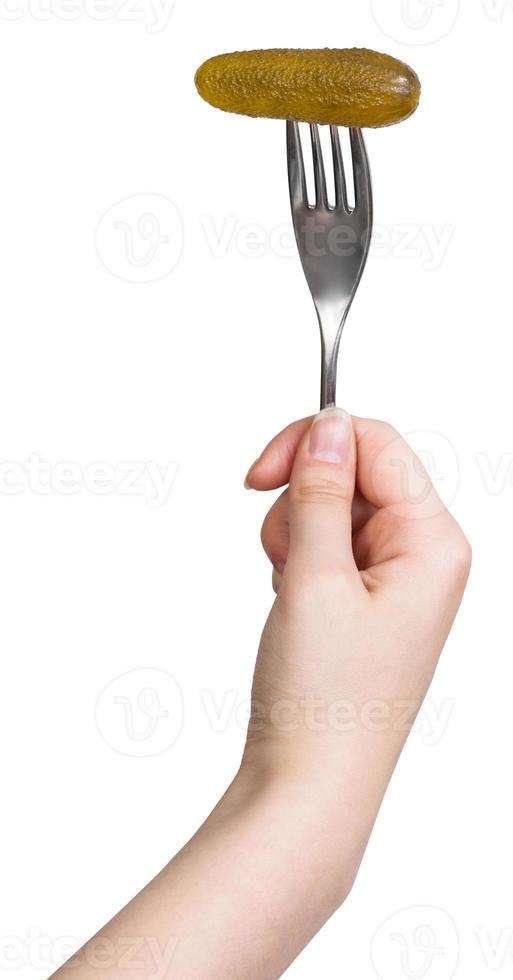 concombre mariné empalé sur une fourchette dans une main de femme photo