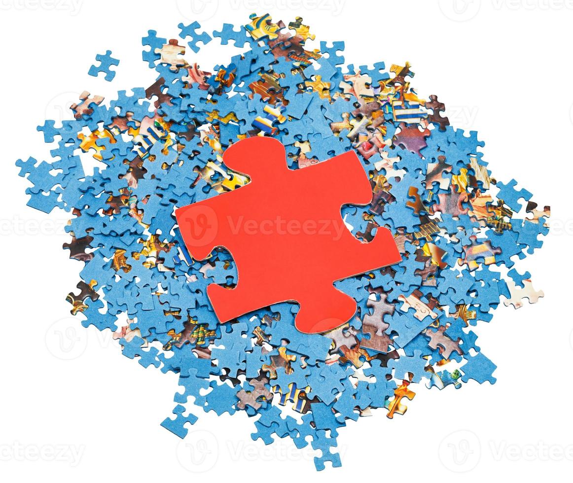 gros morceau rouge sur une pile de puzzles démontés photo