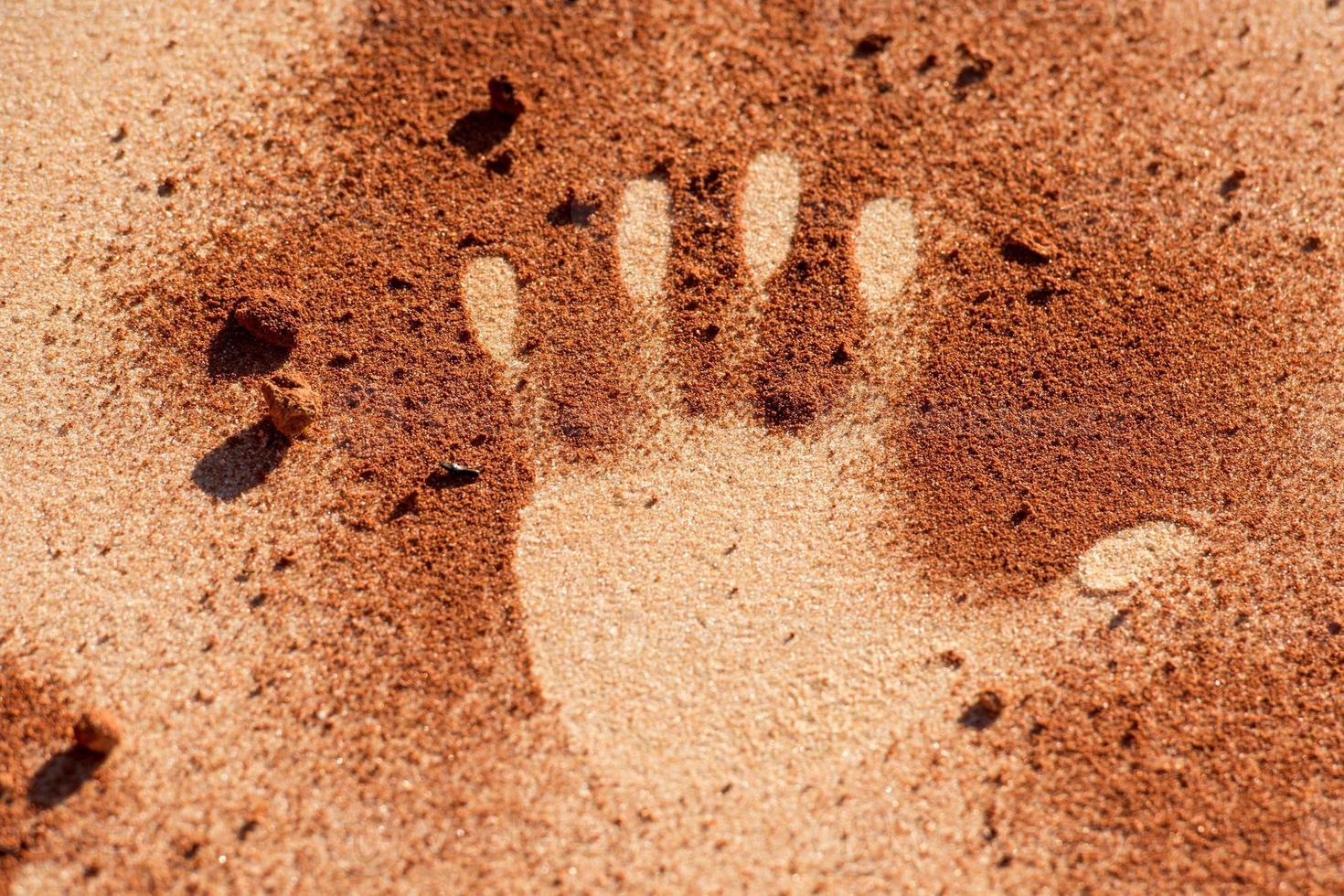 forme de main de sol rouge sur le sable comme le style d'art aborigène photo