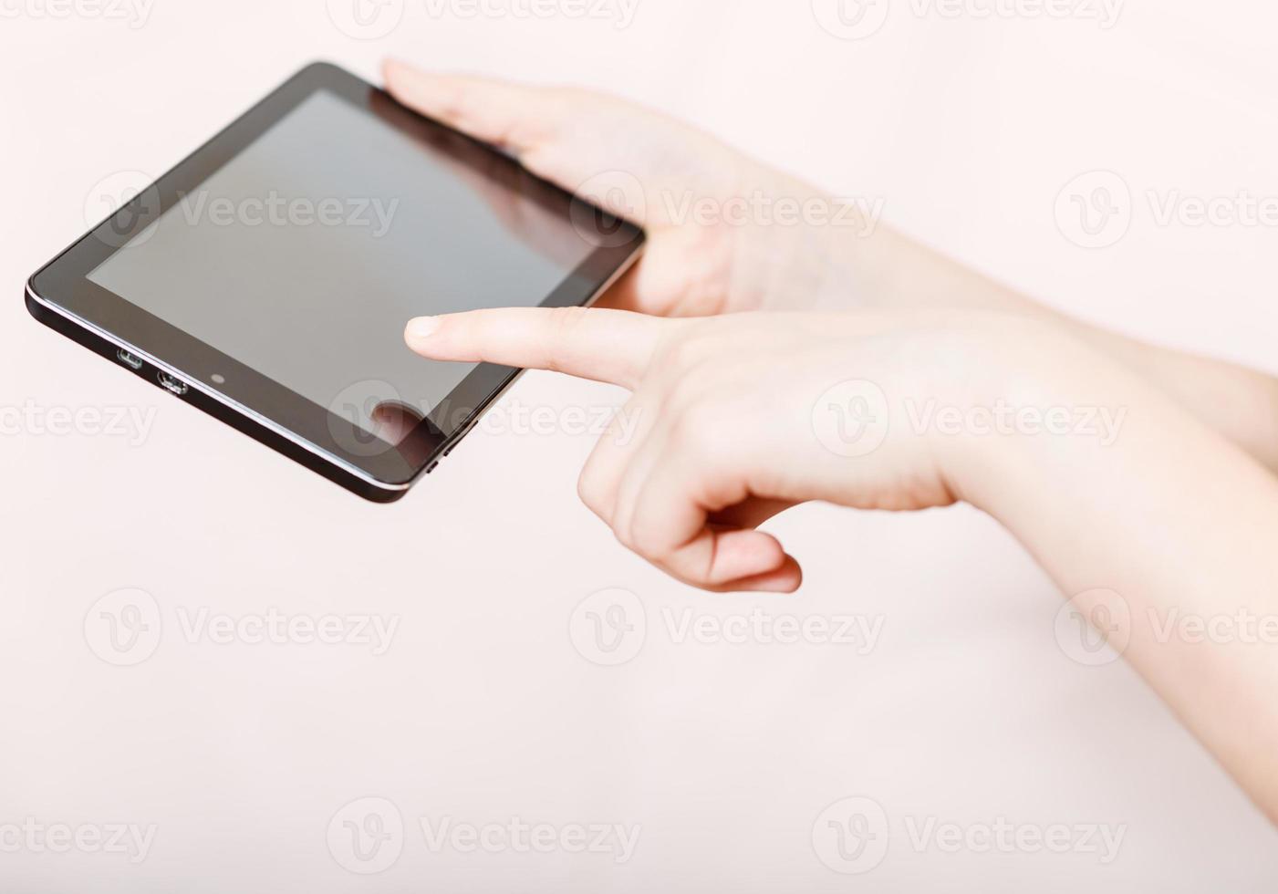 fille tenant et cliquant sur l'écran du Tablet PC photo