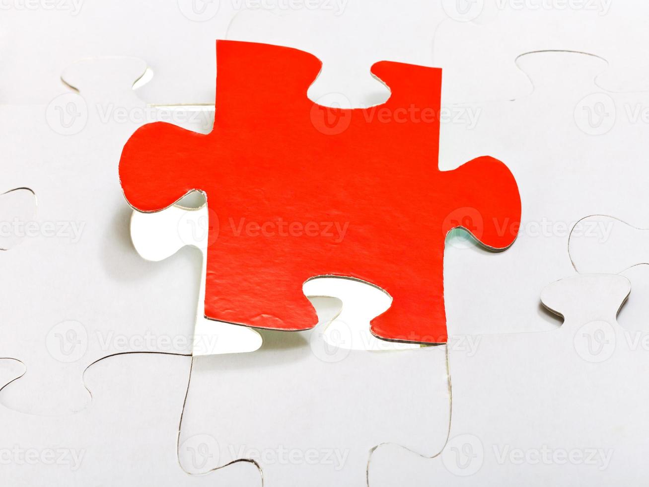 pièce rouge attachée dans des puzzles assemblés photo