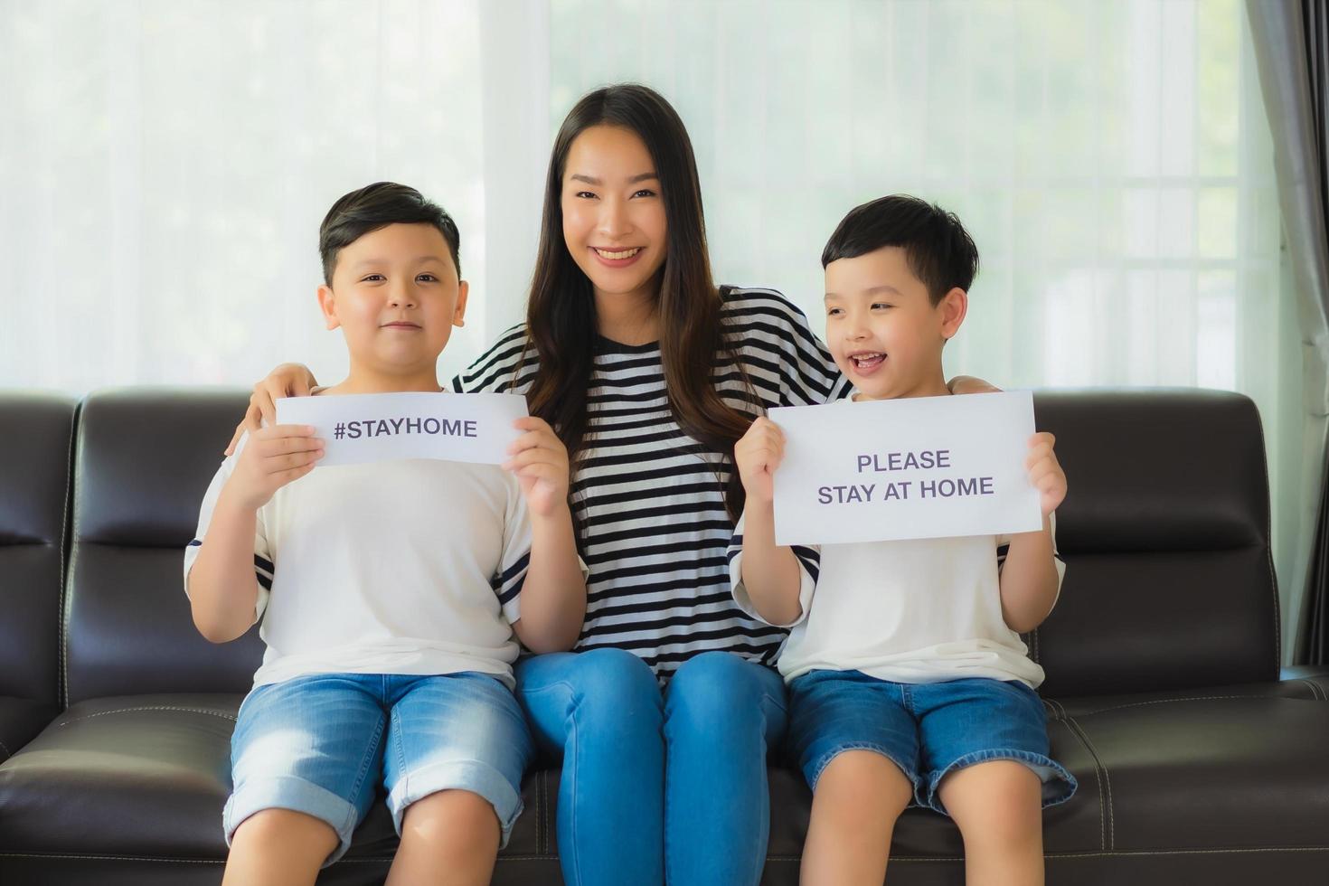 maman avec deux fils brandissant des pancartes pour rester à la maison photo