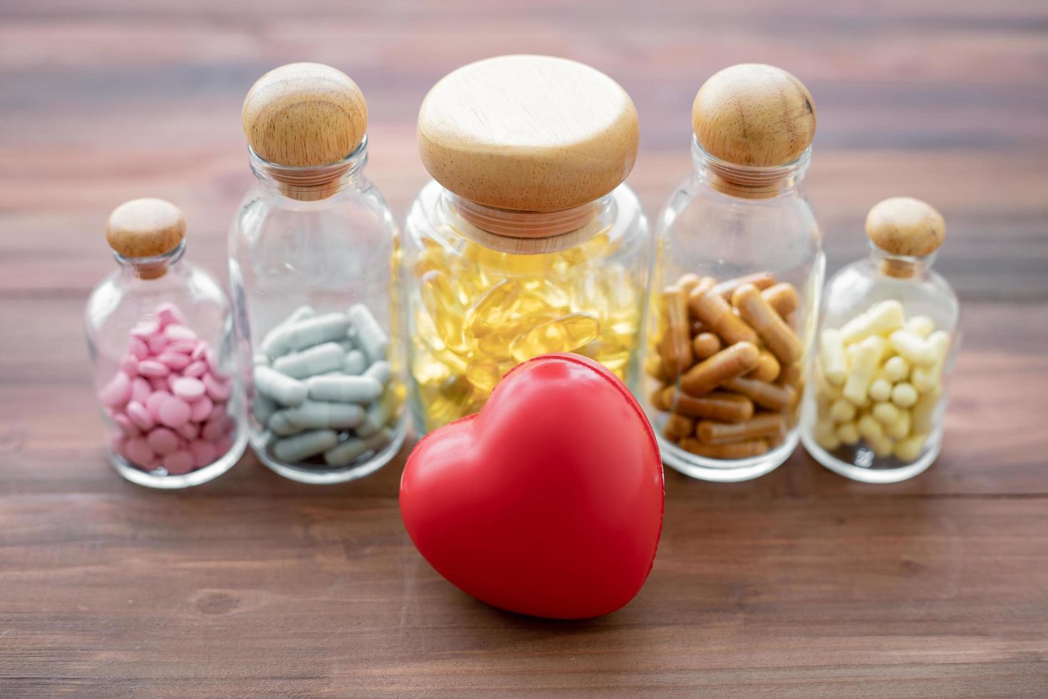 médecine dans des bouteilles en verre avec coeur photo