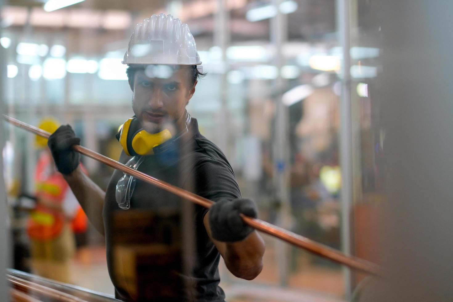 Technicien tenant un tuyau en cuivre au lieu de travail de l'usine photo