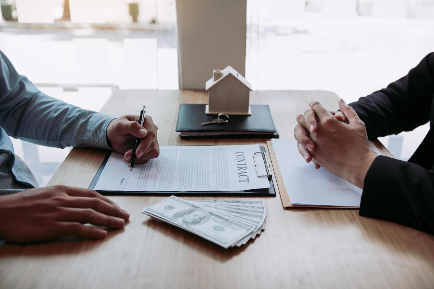 nouvel acheteur de maison signant un contrat au bureau de l'agent photo