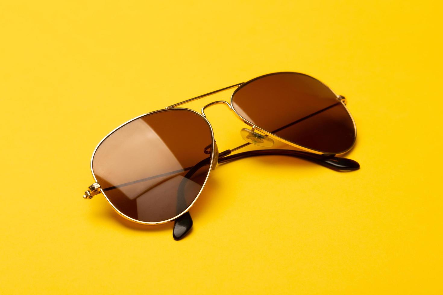 lunettes de soleil aviateur sur fond jaune photo