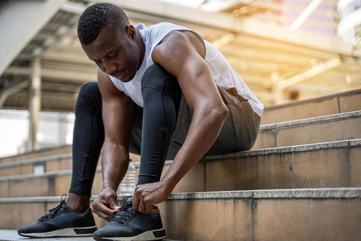 Gros plan d'un jeune modèle athlète laçage des baskets photo