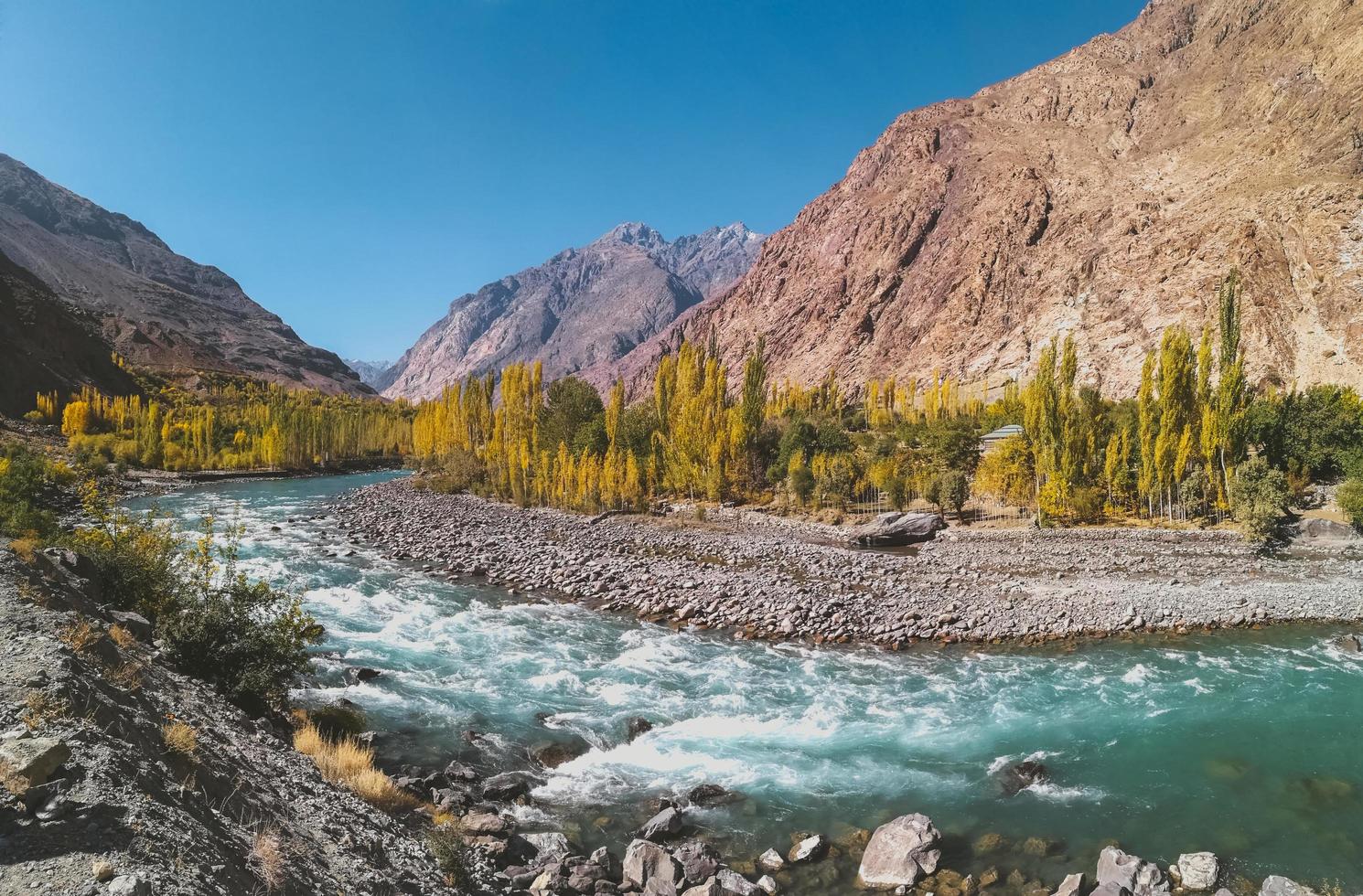 Rivière sinueuse qui coule à travers la chaîne de montagnes Hindu Kush en automne photo