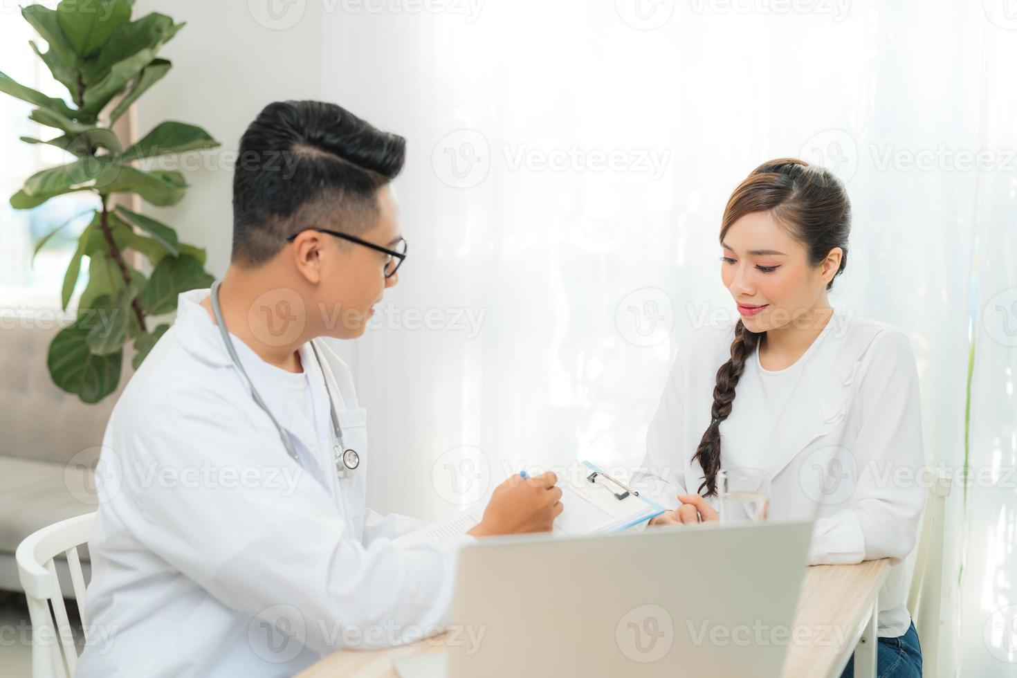 obstétricien-gynécologue masculin travaillant avec une jeune femme stressée en clinique ou à l'hôpital photo