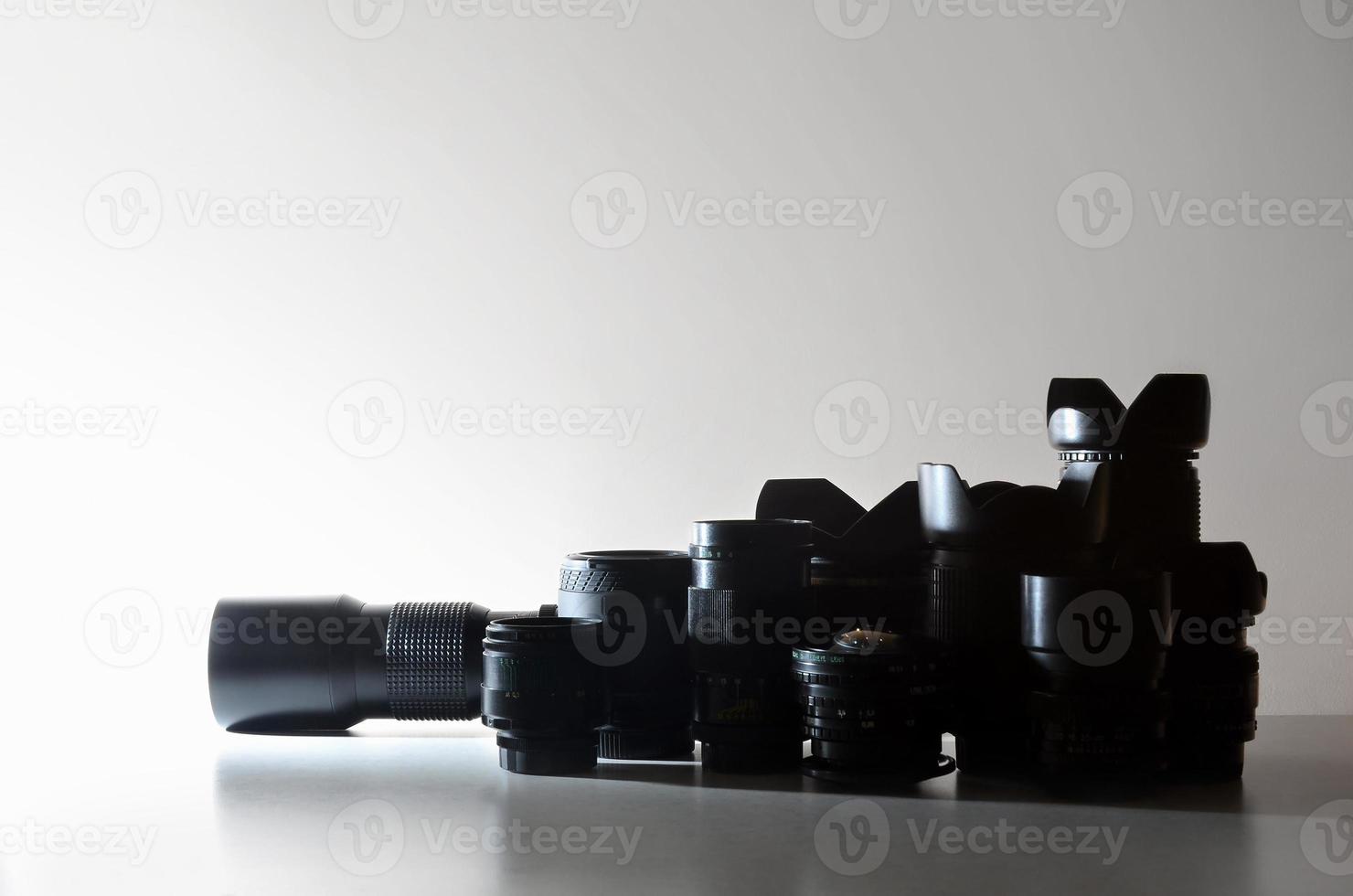 de nombreux objectifs professionnels différents pour appareil photo reflex se trouvent sur un bureau incolore