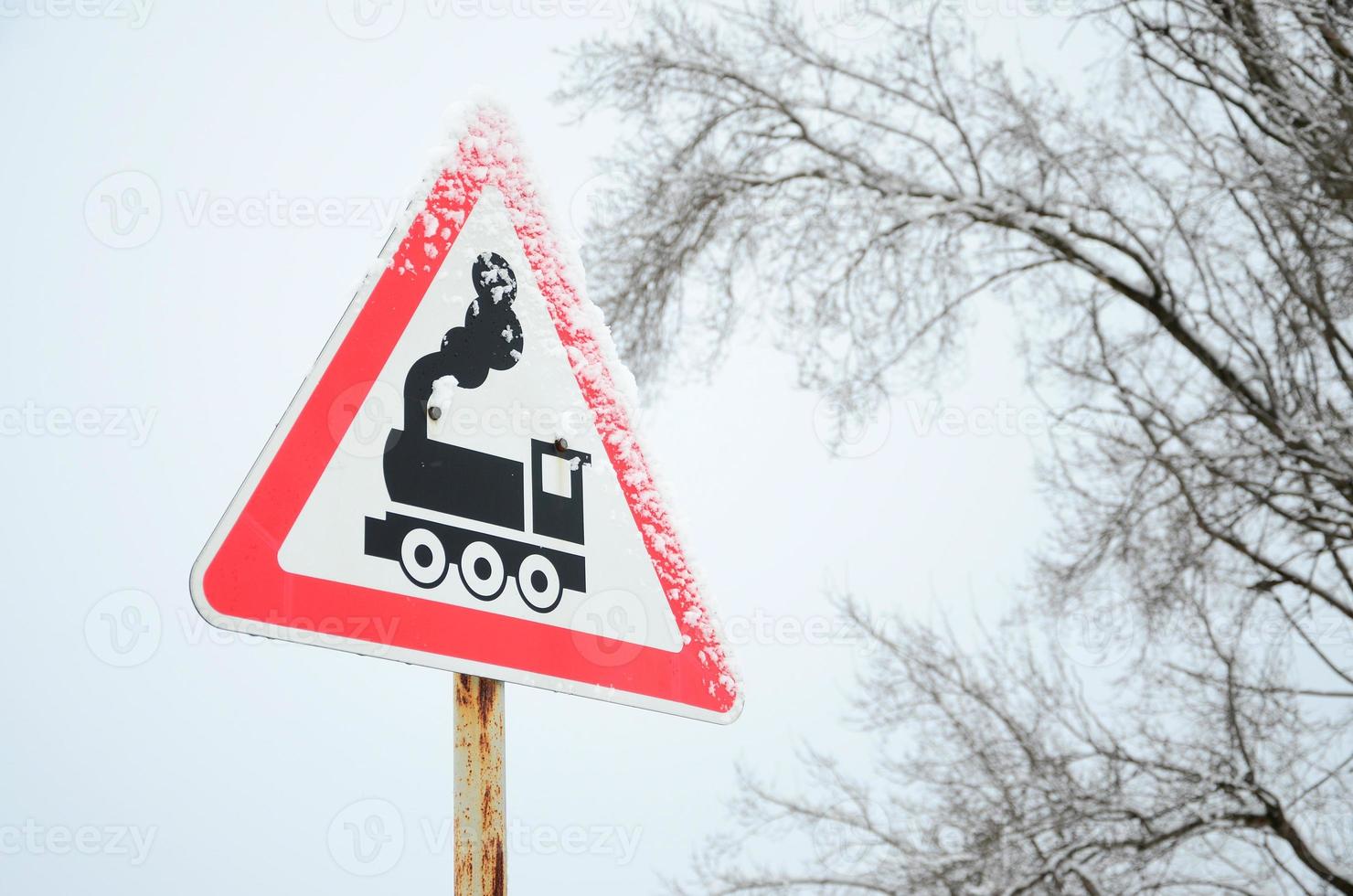 passage à niveau sans barrière. un panneau routier représentant une vieille locomotive noire, situé dans un triangle rouge photo