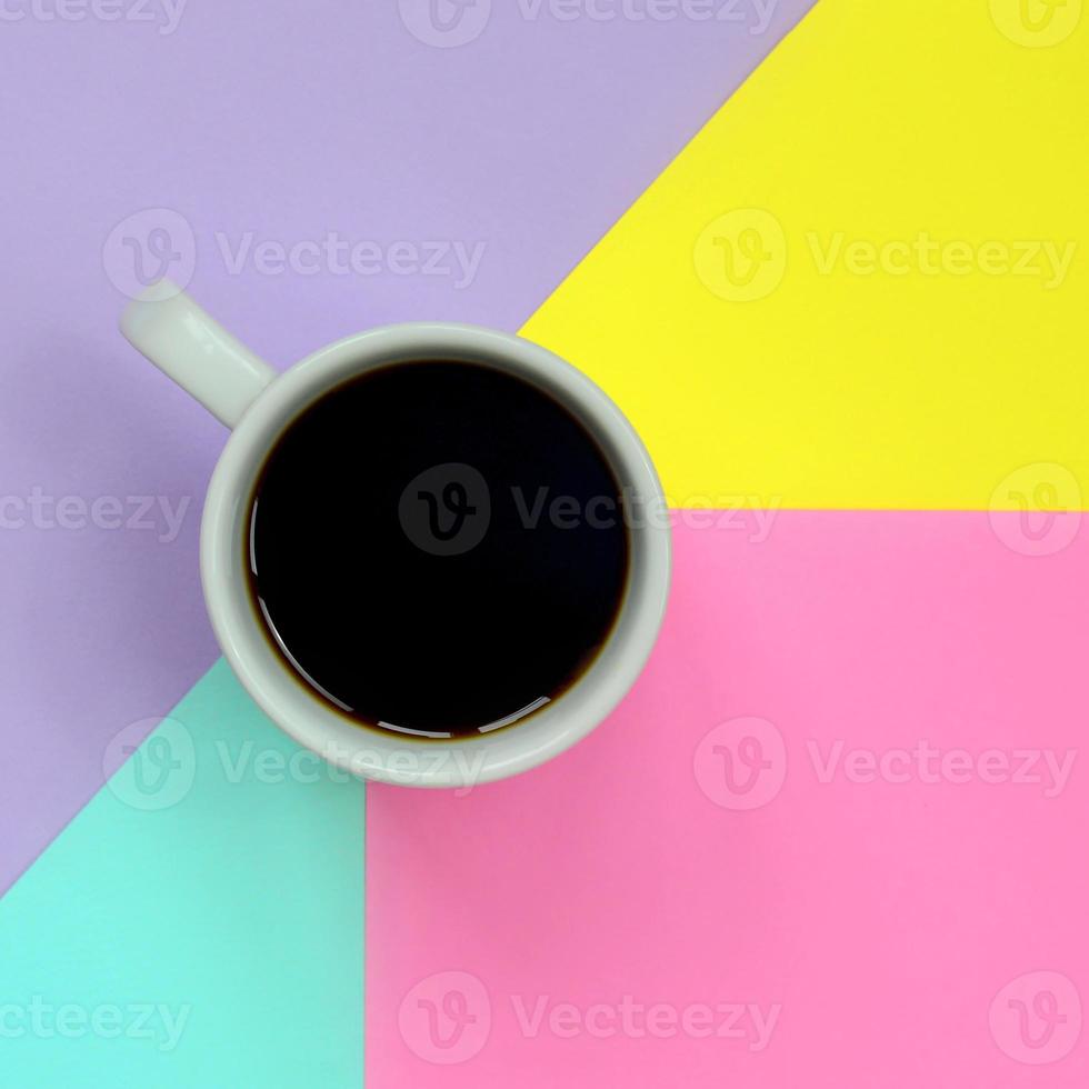 petite tasse à café blanche sur fond de texture de papier de couleurs bleu pastel, jaune, violet et rose de mode dans un concept minimal photo